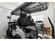 Garage space showcasing a white and black golf cart with upgraded seats and custom wheels at 20795 W San Juan Ave, Buckeye, AZ 85396