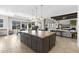 Spacious kitchen with a large granite island, pendant lights and stainless appliances, open to the living space at 20795 W San Juan Ave, Buckeye, AZ 85396