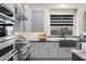 Modern kitchen features stainless steel appliances, gray cabinets and black countertop with a farmhouse sink at 20795 W San Juan Ave, Buckeye, AZ 85396