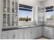 Bright kitchen featuring gray cabinets, black countertops, and natural light from multiple windows at 20795 W San Juan Ave, Buckeye, AZ 85396