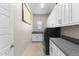 Well-organized laundry room featuring white cabinetry, countertop space, and modern washer-dryer units at 20795 W San Juan Ave, Buckeye, AZ 85396