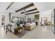 Open living room with beamed ceiling, tile floors, modern furniture, with access to the outside patio at 20795 W San Juan Ave, Buckeye, AZ 85396
