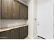 Mudroom features beautiful dark wood cabinets, granite countertops, and a convenient location by the home entrance at 20795 W San Juan Ave, Buckeye, AZ 85396