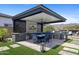 Outdoor kitchen featuring built-in barbecue, bar seating, and lush landscaping, ideal for entertaining at 20795 W San Juan Ave, Buckeye, AZ 85396