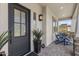 Inviting front porch featuring blue Adirondack chairs and a stylish black front door at 20795 W San Juan Ave, Buckeye, AZ 85396