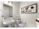 This powder room features neutral color palette, modern fixtures, and stylish artwork at 20795 W San Juan Ave, Buckeye, AZ 85396