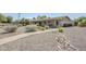 Serene backyard showcases a gravel landscape, brick-paved pathway, and diverse plant life at 2178 E Golf Ave, Tempe, AZ 85282