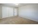 Spacious bedroom with neutral carpet, a ceiling fan, closet, and doorway leading to the rest of the home at 2178 E Golf Ave, Tempe, AZ 85282