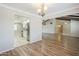 Open dining room with a chandelier, wood floors, and an open doorway to the kitchen at 2178 E Golf Ave, Tempe, AZ 85282