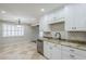 A bright kitchen with stainless dishwasher, granite countertops, and tiled flooring with a view to the back at 2178 E Golf Ave, Tempe, AZ 85282
