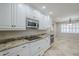 Spacious kitchen boasting white cabinets, granite countertops, stainless steel appliances, and stylish tile flooring at 2178 E Golf Ave, Tempe, AZ 85282