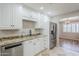 Updated kitchen features white cabinets, granite counters, stainless appliances, and a view of an adjacent dining area at 2178 E Golf Ave, Tempe, AZ 85282
