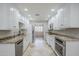 Well-lit kitchen featuring white cabinets, granite countertops, stainless steel appliances, and tile flooring at 2178 E Golf Ave, Tempe, AZ 85282