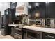 Modern kitchen featuring sleek black cabinetry, stainless steel appliances, and unique mirrored backsplash at 2225 N 38Th Way, Phoenix, AZ 85008