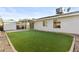 Spacious backyard with artificial grass, covered patio, and a storage shed for outdoor living at 2313 N 87Th Way, Scottsdale, AZ 85257