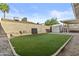 Private backyard featuring low-maintenance artificial turf, block fence, and storage shed at 2313 N 87Th Way, Scottsdale, AZ 85257