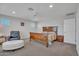 Spacious bedroom featuring a wooden bed frame, a plush chair and an ottoman at 242 N Crosscreek Dr, Chandler, AZ 85225