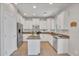 Bright kitchen featuring white cabinets, stainless steel appliances, and wood flooring at 242 N Crosscreek Dr, Chandler, AZ 85225
