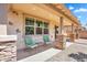 Covered patio with stone columns, comfortable seating, and a view of the well-maintained backyard at 242 N Crosscreek Dr, Chandler, AZ 85225