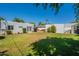 Backyard showing a green lawn, white stucco house, and a shed at 317 E Orange Dr, Phoenix, AZ 85012