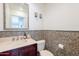 Bathroom featuring a mosaic tiled wall, a large mirror, a pedestal sink and cabinet and standard toilet at 317 E Orange Dr, Phoenix, AZ 85012