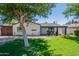 Inviting single-story home with a well-manicured lawn, mature shade trees, and a covered porch at 317 E Orange Dr, Phoenix, AZ 85012