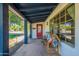 A close-up of the front porch with seating and a bright red door adding character to the home at 317 E Orange Dr, Phoenix, AZ 85012