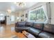Comfortable living room with a large leather sofa, hardwood floors, and bright natural light at 317 E Orange Dr, Phoenix, AZ 85012