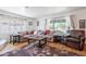 Spacious living room featuring hardwood floors, a large window, comfortable seating, and a corner fireplace at 317 E Orange Dr, Phoenix, AZ 85012