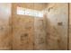 Spa-like shower with travertine tile, glass enclosure, and a built-in niche at 317 E Orange Dr, Phoenix, AZ 85012