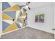 Bedroom featuring colorful geometric wall design, ceiling fan, and a bright, inviting atmosphere at 3201 W Mohawk Ln, Phoenix, AZ 85027