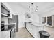 Bright, renovated kitchen featuring white cabinets, stainless steel appliances, and modern lighting fixtures at 3201 W Mohawk Ln, Phoenix, AZ 85027