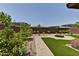 Spacious backyard with a stone pathway, patio, desert landscaping, and built-in fire pit at 3411 E Louise Dr, Phoenix, AZ 85050