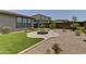 Well-maintained backyard featuring artificial turf, desert landscaping, and a built-in fire pit at 3411 E Louise Dr, Phoenix, AZ 85050