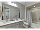 Well-lit bathroom featuring double sinks, subway tile surround, and decorative patterned flooring at 3411 E Louise Dr, Phoenix, AZ 85050