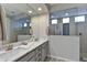 Modern bathroom with double sinks, a large mirror, and a glass-enclosed shower at 3411 E Louise Dr, Phoenix, AZ 85050