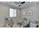 Neutral-toned bedroom featuring a ceiling fan, a bright window, artwork, and gray walls at 3411 E Louise Dr, Phoenix, AZ 85050