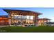 Clubhouse exterior with a modern design, large windows, and outdoor seating by a fire pit at 3411 E Louise Dr, Phoenix, AZ 85050