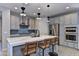 Beautiful kitchen with a waterfall island, stainless steel appliances, and stylish pendant lights at 3411 E Louise Dr, Phoenix, AZ 85050