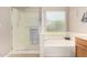 Bright bathroom with a soaking tub, glass-enclosed shower, and a window providing natural light and privacy at 3412 E Kristal Way, Phoenix, AZ 85050