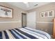 Simply designed bedroom with neutral walls, a double closet and artwork on the walls at 3412 E Kristal Way, Phoenix, AZ 85050