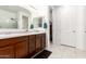 Well-lit bathroom with double sinks, tile flooring, and a shower with glass doors at 3415 S 75Th Dr, Phoenix, AZ 85043