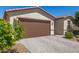 Exterior front of home featuring a brown garage door, brick driveway and landscaping at 3415 S 75Th Dr, Phoenix, AZ 85043