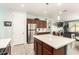 Well-lit kitchen with stainless steel refrigerator, island, and adjoining living spaces creates an inviting atmosphere at 3415 S 75Th Dr, Phoenix, AZ 85043