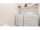 Bright laundry room featuring a washer, dryer and overhead shelving for storage at 3415 S 75Th Dr, Phoenix, AZ 85043