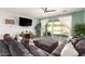 Bright living room with a large sectional, light wood floors and sliding doors opening to the outdoor space at 3415 S 75Th Dr, Phoenix, AZ 85043