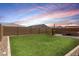 Expansive backyard featuring lush green grass, privacy fencing, and a cozy patio area at 40380 W Jenna Ln, Maricopa, AZ 85138