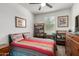 Cozy bedroom with a ceiling fan, colorful bedding, and natural light from the window at 40380 W Jenna Ln, Maricopa, AZ 85138