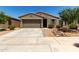 Attractive home featuring desert landscaping, a two-car garage, a tiled roof, and appealing curb appeal at 40380 W Jenna Ln, Maricopa, AZ 85138