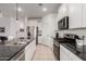 Modern kitchen boasts white cabinets, stainless steel appliances, granite countertops, and a stylish tile backsplash at 40380 W Jenna Ln, Maricopa, AZ 85138